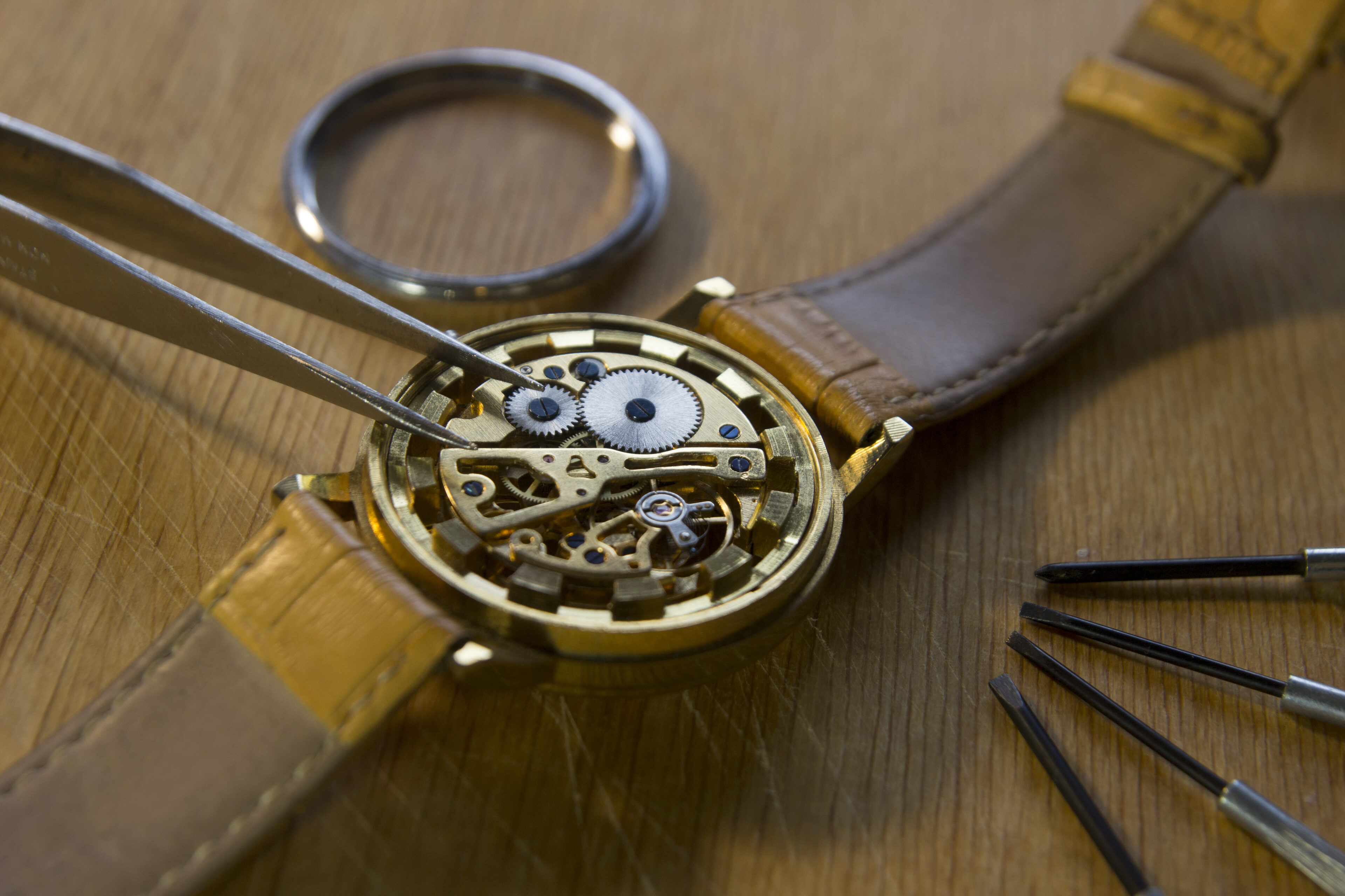 Watchmaker tweezers and screwdrivers on a mechanical watch
